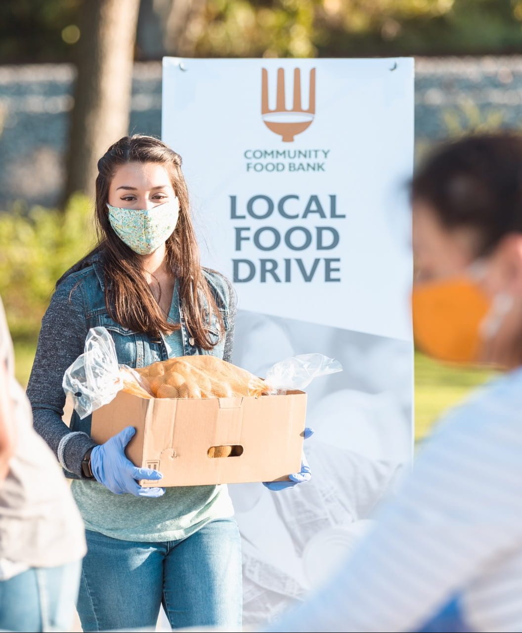 Young woman volunteers at food drive during COVID-19