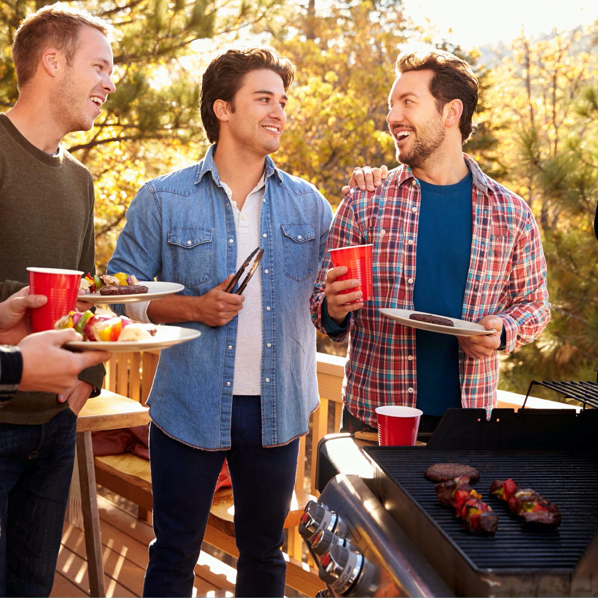 Group Of Gay Male Friends Enjoying Barbeque Together
